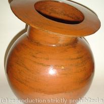 Stoneware pot with spherical body and tilted rim.